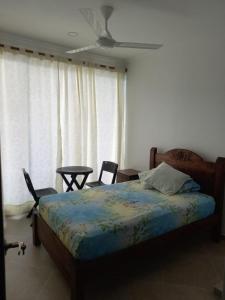 una camera da letto con un letto, due sedie e una finestra di Confortable casa vacacional en Carmen de Apicalá a Carmen de Apicalá