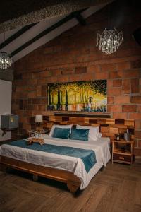 a bedroom with a large bed in a brick wall at Hotel Santa Laura in Jericó