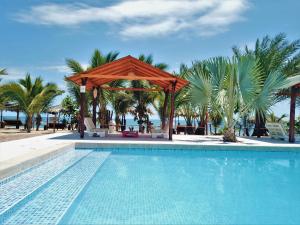 a swimming pool with a gazebo and palm trees at Hotel Punta del Norte Bungalows in Canoas de Punta Sal