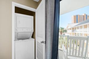 a room with a television and a balcony with aominiumominium at Southwind I-9 in Panama City Beach