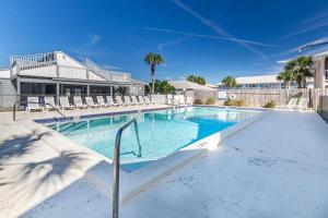 a swimming pool with chairs and a building at Southwind I-9 in Panama City Beach