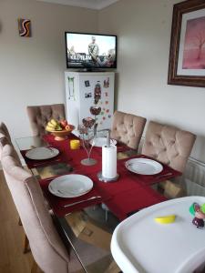 a dining room table with a red table cloth and plates on it at Brooks Homestay in Dundalk