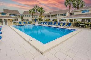 einen Pool in einem Resort mit Stühlen und einem Tisch in der Unterkunft Misty Cove 109 in Destin