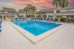 a swimming pool at a resort with chairs and a table at Misty Cove 109 in Destin