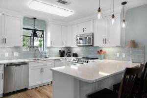a kitchen with white cabinets and a large white island at Misty Cove 109 in Destin