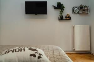 a bedroom with a bed and a tv on a wall at Theo Apartments in Thessaloniki