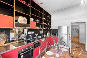 uma cozinha com armários vermelhos e uma mesa com cadeiras em 55 Davey Townhouse 1, Salamanca on your doorstep em Hobart