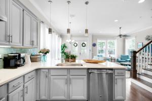 a kitchen with white cabinets and a sink at Beachful Bliss in Santa Rosa Beach