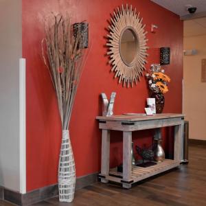 a vase with a mirror on a wall next to a table at Sonesta Simply Suites Clearwater in Clearwater