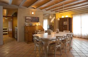 cocina y comedor con mesa y sillas en Masia Els Nocs, en Jorba
