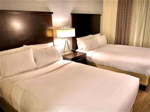 Sonesta ES Suites San Francisco Airport San Bruno في سان برونو: غرفه فندقيه سريرين ومصباح