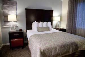 a hotel room with a large bed and two lamps at Sonesta ES Suites San Francisco Airport San Bruno in San Bruno