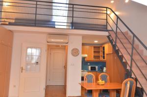 Habitación con escalera y cocina con mesa. en Apartments Vektor Vila Golf, en Rogaška Slatina