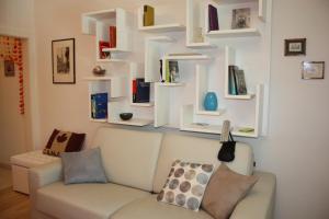 a living room with a white couch and shelves at GoVienna - Charming Studio in Vienna