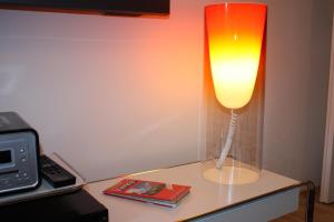 a lamp sitting on a table next to a tv at GoVienna - Charming Studio in Vienna
