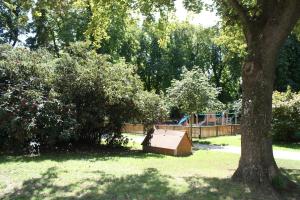 a dog house sitting in the grass next to a tree at GoVienna - Charming Studio in Vienna