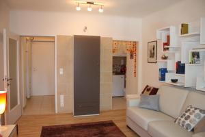 a living room with a couch and a kitchen at GoVienna - Charming Studio in Vienna