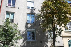 een gebouw met ramen en een boom ervoor bij GoVienna - Charming Studio in Wenen