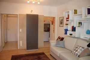 a living room with a couch and a kitchen at GoVienna - Charming Studio in Vienna