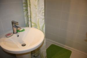a bathroom with a sink and a shower curtain at GoVienna - Charming Studio in Vienna