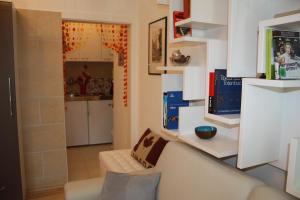 a living room with a white couch and a kitchen at GoVienna - Charming Studio in Vienna