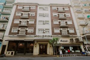 a building on a street with people standing outside of it at Gran Hotel Miglierina in Mar del Plata
