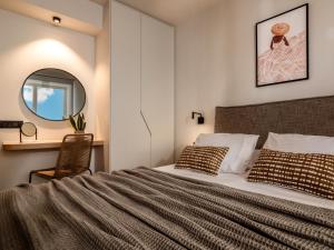 una camera con un grande letto e uno specchio di Point Ephemere Beachfront Apartments a Città di Zante