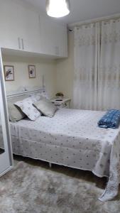 a bedroom with a bed with white sheets and pillows at Casa tipo sobrado. in Arraial do Cabo