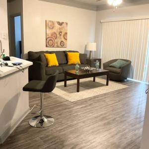 a living room with a couch and a table at An Amazing 2 bedroom 2 full Bath Apartment Unit with Desk and Rental Car Available in Houston