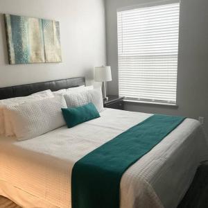 a bedroom with a large bed with a green blanket at An Amazing 2 bedroom 2 full Bath Apartment Unit with Desk and Rental Car Available in Houston