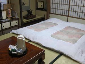 Postel nebo postele na pokoji v ubytování Fujiya Ryokan