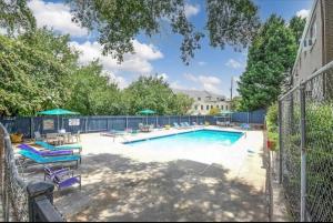 a swimming pool with chairs and a fence at Wine Down Suite King Bd, 400mbps, Kitchen,Free Parking Pool in Atlanta