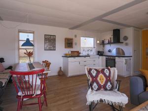 cocina y sala de estar con mesa y sillas en Holiday home Jægerspris XLI, en Jægerspris