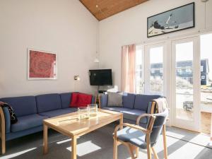 Vestervigにある5 person holiday home in Vestervigのリビングルーム(青いソファ、テーブル付)
