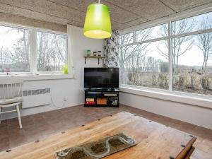 a living room with a flat screen tv and windows at 6 person holiday home in Farsø-By Traum in Farsø