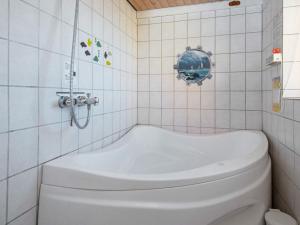 een badkamer met een wit bad en een toilet bij 6 person holiday home in Lemvig in Ferring