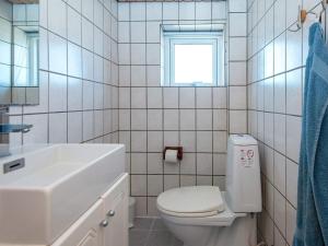 a bathroom with a toilet and a sink and a window at 6 person holiday home in Lemvig in Ferring