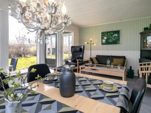 een woonkamer met een tafel en een kroonluchter bij Holiday Home Fyrrevej in Thyholm