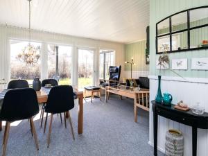 a living room with a table and chairs at Holiday Home Fyrrevej in Thyholm