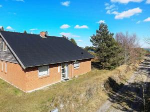 una casa de ladrillo rojo con techo negro en 8 person holiday home in Thyholm, en Thyholm