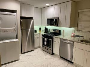 a kitchen with stainless steel appliances and white cabinets at Wine Down Suite King Bd, 400mbps, Kitchen,Free Parking Pool in Atlanta