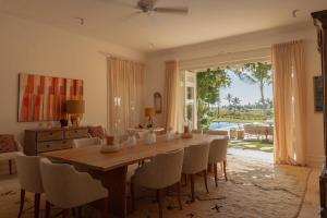 蓬塔卡納的住宿－Luxurious fully-staffed villa with amazing view in exclusive golf & beach resort，一间带木桌和椅子的用餐室
