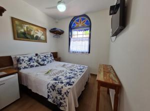 a small bedroom with a bed and a window at Pousada do Vovô Luiz in Conservatória