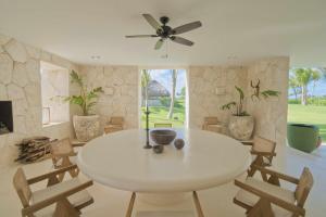 ein weißes Esszimmer mit einem weißen Tisch und Stühlen in der Unterkunft Unique golf front villa with modern design in exclusive beach resort in Punta Cana