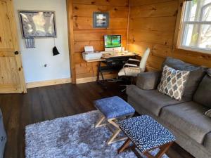 a living room with a couch and a desk with a computer at Mountain Creek Lodge in Maggie Valley
