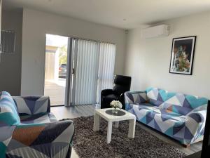 sala de estar con sofá y mesa en 4 bedroom home fully furnished in Papakura, Auckland, en Auckland