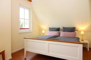 a white bed in a room with a window at Ferienhaus in Wohlenberg nahe der Ostsee in Wohlenberg