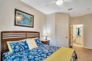 a bedroom with a blue and white bed and a door at Magical Adventure Condo w Waterpark near Disney No Resort Fees in Orlando