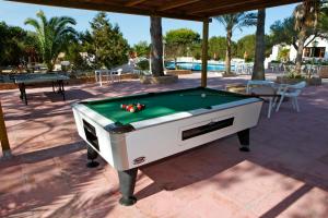 a pool table with balls on it on a patio at Hotel Ca Marí in Playa Migjorn