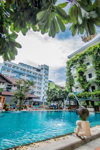 a swimming pool with a fountain in front of a building at Sutus Court 5 in Pattaya Central